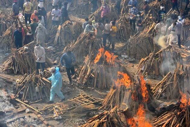 NEW DELHI, INDIA - APRIL 26: Funeral pyres of people who died of Covid-19 burning simultaneously at Gazipur crematorium on April 26, 2021 in New Delhi, India. India has registered 2,762 new deaths and 319,315 new infections recording more than 300,000 daily Covid-19 cases for the fifth day in a row, reaching a new record peak. (Photo by Raj K Raj Hindustan Times) Cremation Of Covid-19 Victims