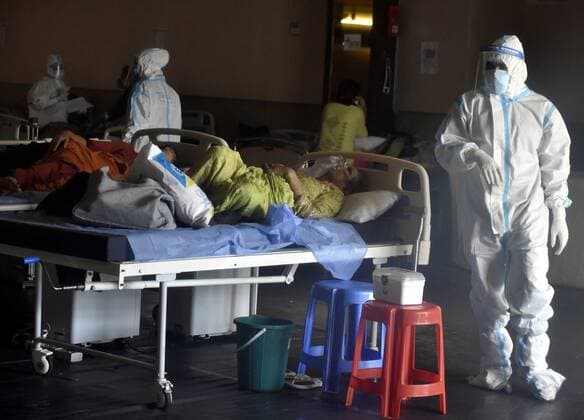 NEW DELHI, INDIA - APRIL 26: Doctor for You Medical staff in PPE coveralls attend to patients housed in the Shehnai Banquet Hall Covid-19 care centre attached to LNJP Hospital on April 26, 2021 in New Delhi, India. India has registered 2,762 new deaths and 319,315 new infections recording more than 300,000 daily Covid-19 cases for the fifth day in a row, reaching a new record peak. (Photo by Sonu Mehta Hindustan Times) Temporary Covid-19 Care Centre In Delhi