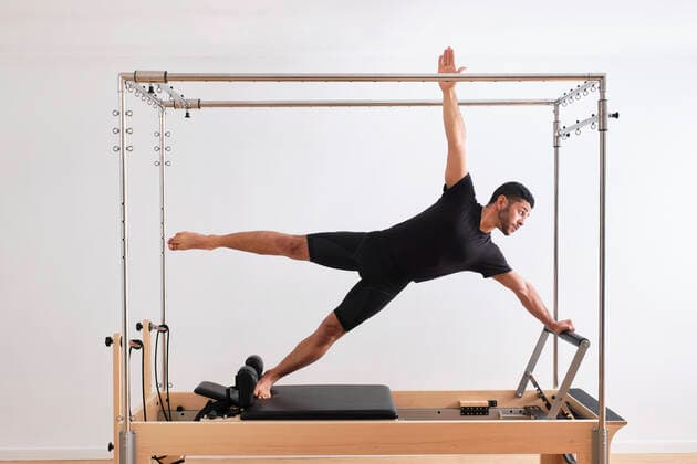 Determined male athlete balancing while practicing pilates in exercise room model released Symbolfoto property released AODF00357