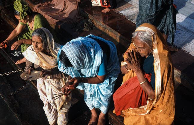 13.03.2010, Haridwar, Uttarakhand, Indien, Asien - Weibliche Pilger in ihren bunten, traditionellen Gewaendern beten waehrend des religioesen Hindufestes Purna Kumbh Mela am Har Ki Pauri Ghat am Ufer des heiligen Ganges.