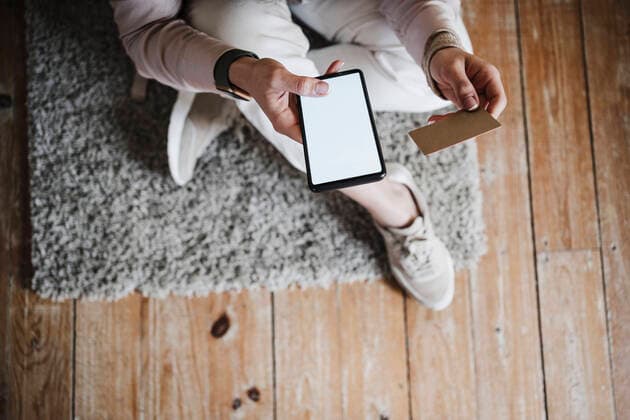 Hands of woman holding smart phone and credit card at home model released Symbolfoto property released EBBF02899