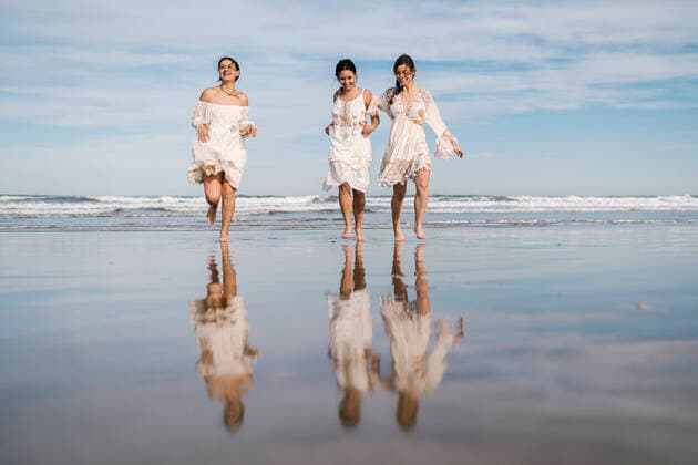 Creative Highlights Symbolbilder Carefree young women running together at beach model released Symbolfoto EGAF02198