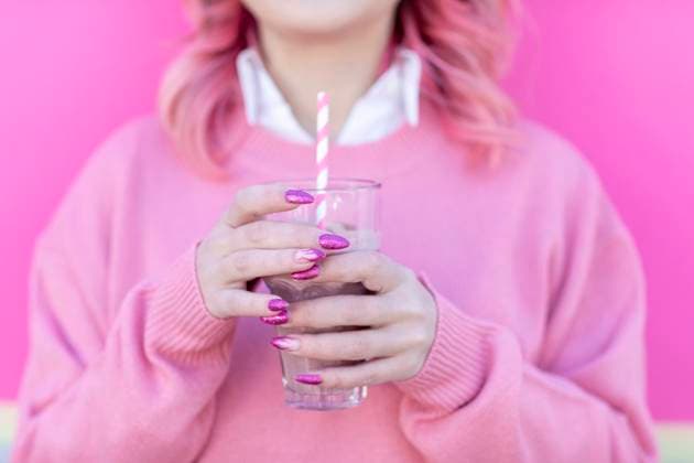 Woman with glass of milkshake in front of wall model released Symbolfoto EIF00730