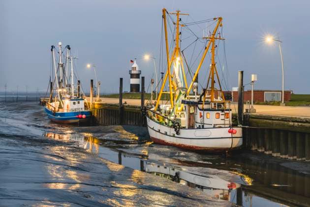 Germany, Lower Saxony, Wurster Nordseekuste, Fishing boats moored in beachside harbor at dusk KEBF01846
