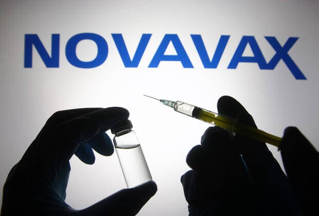 April 27, 2021, Ukraine: In this photo illustration, silhouette of hands in medical gloves hold a medical syringe and a vial in front of Novavax logo. Ukraine - ZUMAs197 20210427_zab_s197_066 Copyright: xPavloxGoncharx