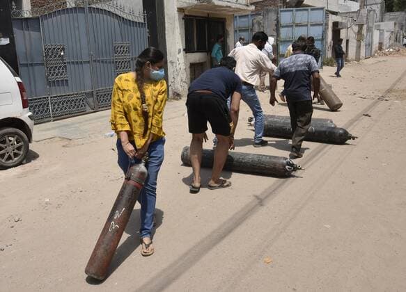 GURUGRAM, INDIA - APRIL 27: People with oxygen cylinders outside a refilling station, at Sector 14 on April 27, 2021 in Gurugram, India. As Covid-19 cases continued to surge in Gurugram with over 29,681 active cases people are struggling to get hospital beds, ventilators, oxygen cylinders, injections and medicines with the health infrastructure in the state almost stretched to its limit. (Photo by Vipin Kumar Hindustan Times) India Faces Oxygen Crisis As Covid-19 Cases Mount
