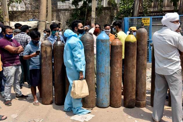 NEW DELHI, INDIA - APRIL 27: People wait to refill empty oxygen cylinders at a plant in Naraina, on April 27, 2021 in New Delhi, India. As Covid-19 cases continued to surge in Delhi with over 98,264 active cases people are struggling to get hospital beds, ventilators, oxygen cylinders, injections and medicines with the health infrastructure in the state almost stretched to its limit. (Photo by Sanjeev Verma Hindustan Times) India Faces Oxygen Crisis As Covid-19 Cases Mount