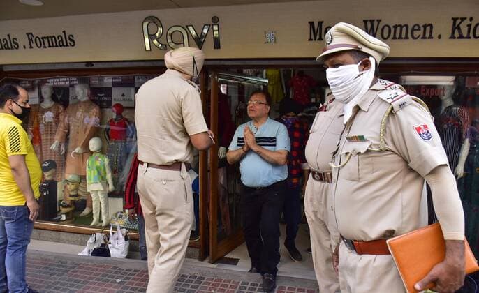 AMRITSAR, INDIA - APRIL 27: Punjab police personnel making announcement to shopkeepers to close their businesses before 5 PM as per new Covid-19 night curfew orders by the state government, at Katra Jaimal Singh on April 27, 2021 in Amritsar, India. The Punjab government on Monday ordered a weekend lockdown and extended the night curfew by two hours in a bid to tackle the surge in coronavirus cases. The government has also ordered the closure of shops by 5 pm. (Photo by Sameer Sehgal Hindustan Times) Punjab Government Orders Closure Of Shops By 5 PM