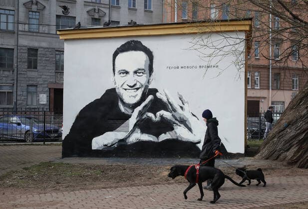 Bilder des Jahres 2021, News 04 April ST PETERSBURG, RUSSIA - APRIL 28, 2021: A woman and dogs walk by a mural depicting Russian opposition activist Alexei Navalny and reading The hero of new times on a transformer house in Pushkarsky Garden. The mural was discovered in the early morning of April 28 and painted over around 10:30 am. Alexander Demianchuk TASS  TS0FE4A9