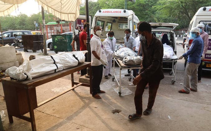 April 28, 2021, New Delhi, India: (EDITORS NOTE: Image depicts death).Healthcare worker and family members carry a body of their relative who died from coronavirus Covid-19 virus for cremation at a crematorium..India faces the world fastest growing number of Covid-19 cases with 360,927 new confirmed infections, the highest single day count in the country and more than 3,293 death in the month of April 2021. New Delhi India - ZUMAs197 20210428_zaa_s197_063 Copyright: xNaveenxSharmax