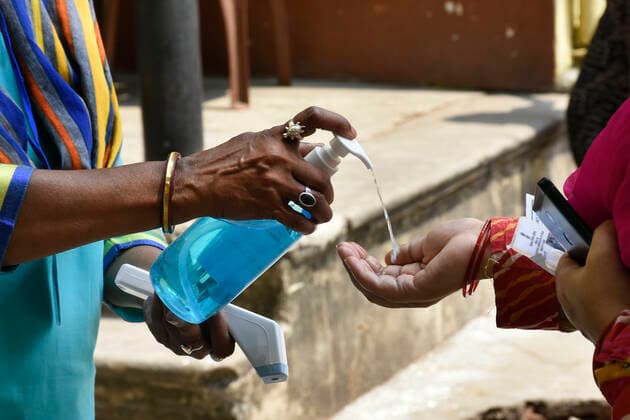 India: 8th Phase of Polling at West Bengal A vote worker giving hand sanitizer before enter the Polling Booth at Kolkata, West Bengal. Kolkata India Copyright: SuraranjanxNandi
