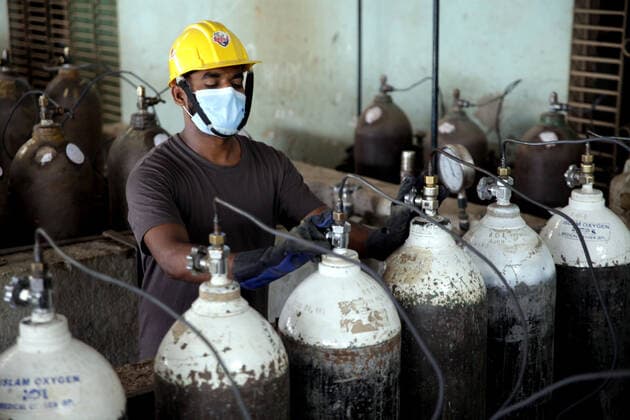(210429) -- NARAYANGANJ, April 29, 2021 -- A worker fills oxygen cylinders at a refilling station in Narayanganj on the outskirts of Bangladesh capital Dhaka, April 29, 2021. Workers at oxygen refilling stations including the one in Narayanganj are now working overtime to meet the growing demand on hospitals. BANGLADESH-NARAYANGANJ-COVID-19-OXYGEN CYLINDERS Salim 