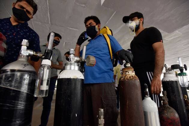 NEW DELHI, INDIA - APRIL 29: People waiting with empty cylinders for free oxygen refills at a gurudwara, in Greater Kailash Part-1, on April 29, 2021 in New Delhi, India. In the last 24 hours, recorded 3,86,654 fresh Covid-19 cases and 3,501deaths, which is the highest in the country so far. At present, there are 31,64,825 active cases in India. As Covid-19 cases continued to surge in India people are struggling to get hospital beds, ventilators, oxygen cylinders, injections and medicines with the health infrastructure in the state almost stretched to its limit. (Photo by Sanjeev Verma Hindustan Times) India Faces Oxygen Crisis As Covid-19 Cases Mount