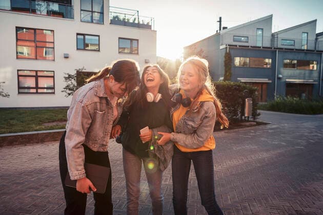 IMAGO Creative, Jahreszeit Herbst, Ferien Cheerful female friends laughing on footpath against building Sweden, Malmo, model released Copyright: xKentarooxTrymanx , MA86349