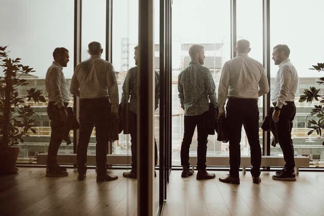 IMAGO Creative: Dichotomien, Reflexionen Business people discussing with each other while standing in front of window at office Sweden, Stockholm, model released Copyright: xMaskotx , MA86406