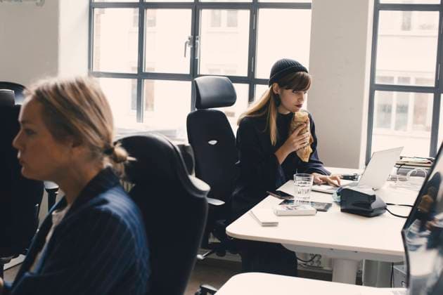 IMAGO Creative: Kreative Renaissance -- der junge Entrepreneur Businesswoman eating food while working on laptop at office Sweden, Stockholm, model released, property released Copyright: xMaskotx , MA85879