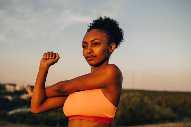 IMAGO Creative, Lifestyle, Tik Tok-Trend thatgirl Female athlete doing stretching exercise against sky during sunset Sweden, Stockholm, model released Copyright: xMaskotx , MA86076