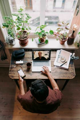 Businessman using smart phone while discussing with colleague on video call at home office Sweden, Stockholm, model released, property released Copyright: xMaskotx , MA86233