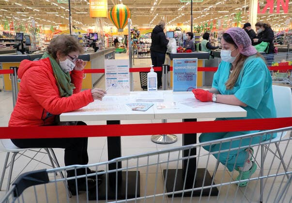 MOSCOW, RUSSIA â€” APRIL 30, 2021: A woman fills in paperwork before receiving the Gam-COVID-Vac vaccine (under the brand name of Sputnik V) at a temporary vaccination site in the Globus superstore. A mobile vaccination team is providing vaccines free of charge and without prior sign-up. Since the start of the pandemic, Moscow has confirmed more than 1,092,800 cases of COVID-19. Since the beginning of April, the number of new confirmed cases has been increasing in the Russian capital by more than 1,500 daily. Gavriil Grigorov TASS  TS0FEB2B