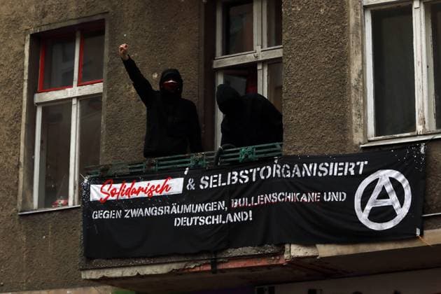 VON DER KRISE ZUR ENTEIGNUNG! - Demonstration für eine soziale und demokratische Lösung der aktuellen Gesundheits- und Wirtschaftskrise - Hunderte protestieren in Berlin auf den Weddinger Straßen zwischen Leopoldplatz und Gesundbrunnen. - Berlin, Deutschland, DEU, GER, 30.04.2021, Berlin-Mitte (Ortsteil Wedding): Zur Demonstration am Vorabend des 1. Mai hat die linke Stadtteilgruppe Hände weg vom WEDDING! aufgerufen, die sich seit 2012 gegen den Ausverkauf des Weddings und andere soziale Missstände organisiert. Aufgrund der Corona-Pandemie tragen die Demonstranten Mundschutz und halten möglichst Abstand zueinander. Protestaktion im selbstverwalteten Hausprojekt der Schererstraße 8: Vermummte Aktivisten auf einem Balkon (links: Akt