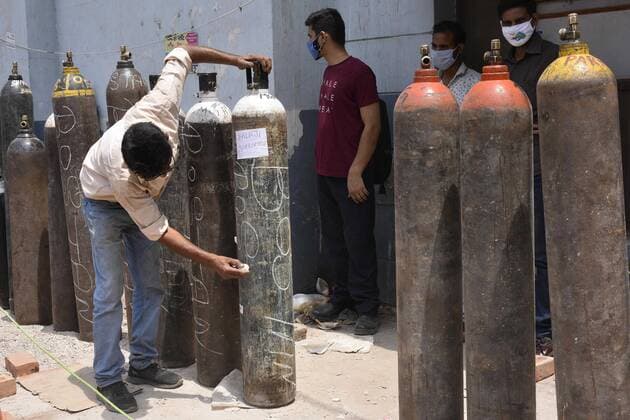 GURUGRAM, INDIA - APRIL 30: Family members of Covid-19 patients waiting with empty oxygen cylinders in a queue outside a filling station at Sector 14 on April 30, 2021 in Gurugram, India. (Photo by Vipin Kumar Hindustan Times) India Faces Oxygen Crisis As Covid-19 Cases Mount