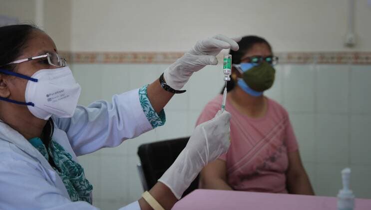 Coronavirus, Eindrücke aus Indien JAIPUR, INDIA - MAY 1: A person looks on while a medic prepares a dose of a Covid-19 vaccine, at J K Lon Hospital, on May 1, 2021 in Jaipur, India. (Photo by Himanshu Vyas Hindustan Times) COVID-19 Vaccination Drive