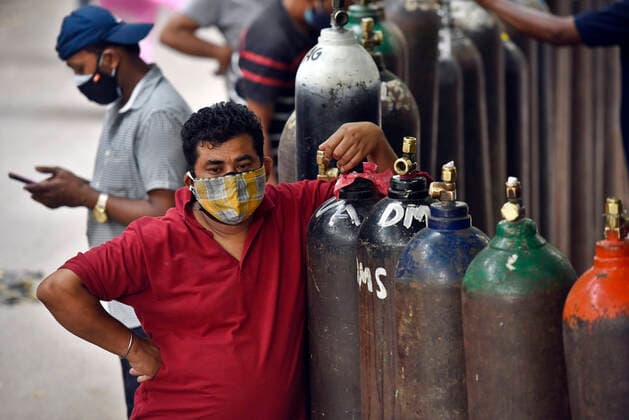 NEW DELHI, INDIA - MAY 2: A rush of people waiting to refill empty oxygen cylinders, at Bhogal Jangpura, on May 2, 2021 in New Delhi, India. (Photo by Sanjeev Verma Hindustan Times ) Daily Life Amid Coronavirus Pandemic In India