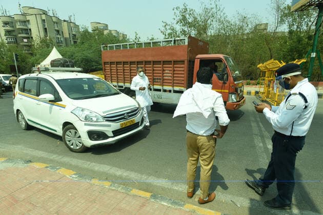 NOIDA, INDIA - MAY 2: Police personnel screening commuters at Noida- Delhi entry gate in Sector 14A during curfew imposed to curb the spread of coronavirus disease (Covid-19), on May 2, 2021 in Noida, India. (Photo by Sunil Ghosh Hindustan Times ) Daily Life Amid Coronavirus Pandemic In India