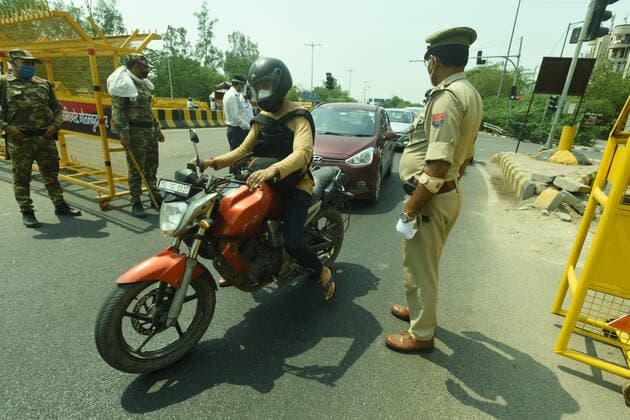 NOIDA, INDIA - MAY 2: Police personnel screening commuters at Noida- Delhi entry gate in Sector 14A during curfew imposed to curb the spread of coronavirus disease (Covid-19), on May 2, 2021 in Noida, India. (Photo by Sunil Ghosh Hindustan Times ) Daily Life Amid Coronavirus Pandemic In India