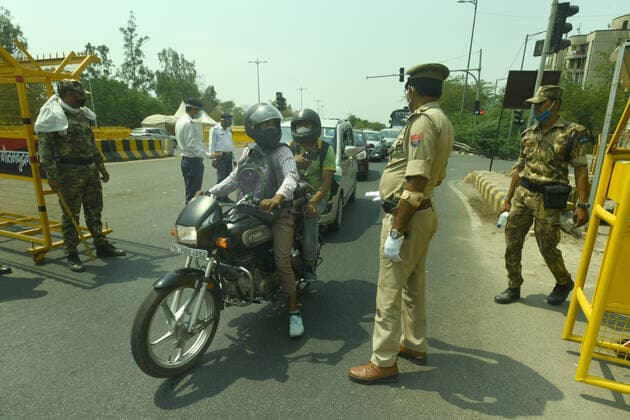 NOIDA, INDIA - MAY 2: Police personnel screening commuters at Noida- Delhi entry gate in Sector 14A during curfew imposed to curb the spread of coronavirus disease (Covid-19), on May 2, 2021 in Noida, India. (Photo by Sunil Ghosh Hindustan Times ) Daily Life Amid Coronavirus Pandemic In India