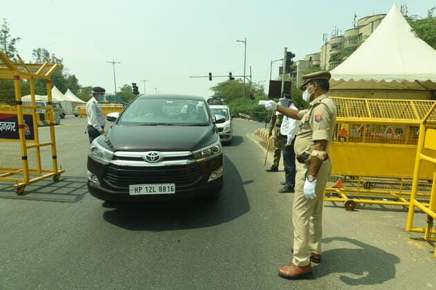 NOIDA, INDIA - MAY 2: Police personnel screening commuters at Noida- Delhi entry gate in Sector 14A during curfew imposed to curb the spread of coronavirus disease (Covid-19), on May 2, 2021 in Noida, India. (Photo by Sunil Ghosh Hindustan Times ) Daily Life Amid Coronavirus Pandemic In India