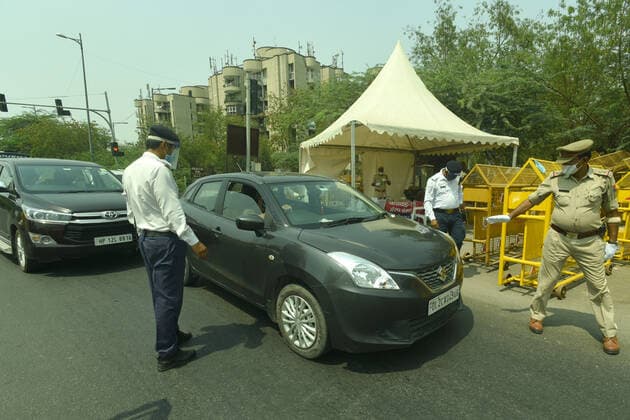 NOIDA, INDIA - MAY 2: Police personnel screening commuters at Noida- Delhi entry gate in Sector 14A during curfew imposed to curb the spread of coronavirus disease (Covid-19), on May 2, 2021 in Noida, India. (Photo by Sunil Ghosh Hindustan Times ) Daily Life Amid Coronavirus Pandemic In India