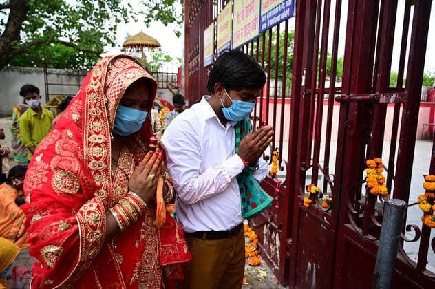 May 3, 2021, Prayagraj, Uttar Pradesh, India: Prayagraj: A Newly married couple perform prayer outside closed Alopi Devi Temple during government imposed weekend Lockdown in Prayagraj on Monday, May 03, 2021. Prayagraj India - ZUMAv115 20210503_zap_v115_037 Copyright: xPrabhatxKumarxVermax