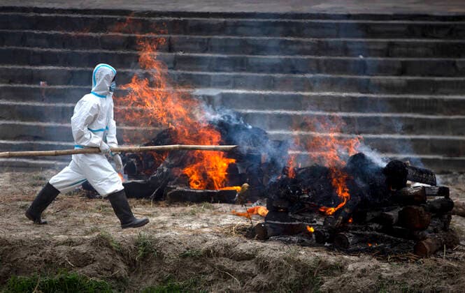 (210503) -- KATHMANDU, May 3, 2021 -- A worker cremates victims who died from COVID-19 at Pashupatinath Temple crematorium in Kathmandu, Nepal, May 3, 2021. (Photo by Xinhua) NEPAL-KATHMANDU-COVID-19 VICTIMS-CREMATION SulavxShrestha 
