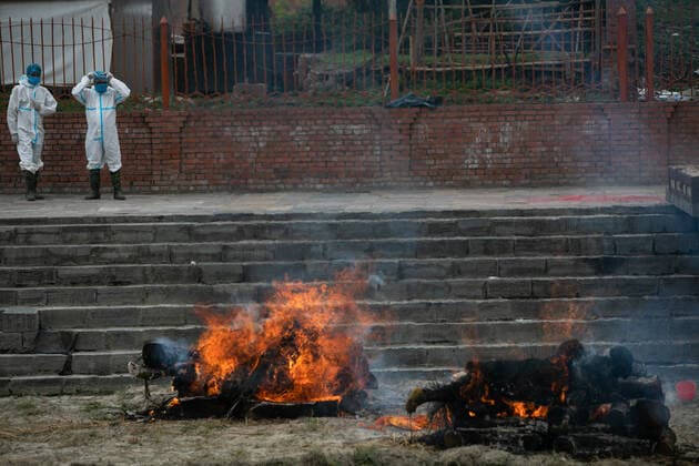May 3, 2021, Kathmandu, Nepal: Nepalese workers wearing protective suits stand near the burning dead bodies of Coronavirus (COVID-19) victims during a cremation at the premises of Pashupatinath temple in Kathmandu..Electronic crematorium situated in Pashupati is congested with COVID-19 death bodies arriving for cremation. As there is no space inside the crematorium due to limited capacity death bodies of the deceased are being burned near the bank of Bagmati River at the Premises of Pashupatinath temple. Kathmandu Nepal - ZUMAs197 20210503_zaa_s197_007 Copyright: xPrabinxRanabhatx