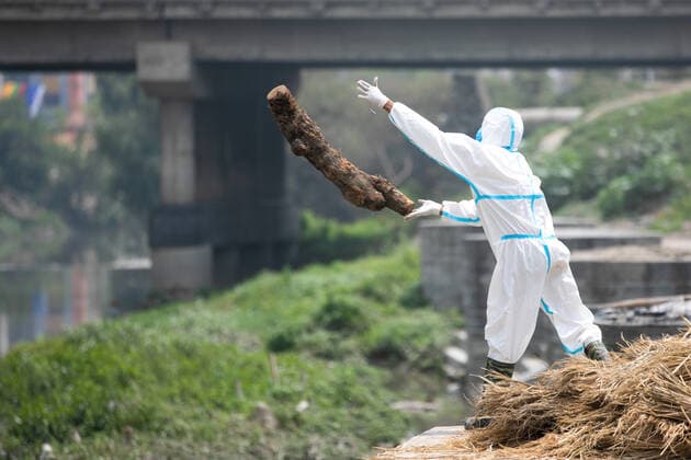 May 3, 2021, Kathmandu, Nepal: A workers wearing personal protective equipment (PPE) prepares a funeral pyre for the body of a person who has died of COVID-19 at the premises of Pashupatinath temple ..Electronic crematorium situated in Pashupati is congested with COVID-19 death bodies arriving for cremation. As there is no space inside the crematorium due to limited capacity death bodies of the deceased are being burned near the bank of Bagmati River at the Premises of Pashupatinath temple. Kathmandu Nepal - ZUMAs197 20210503_zaa_s197_009 Copyright: xPrabinxRanabhatx