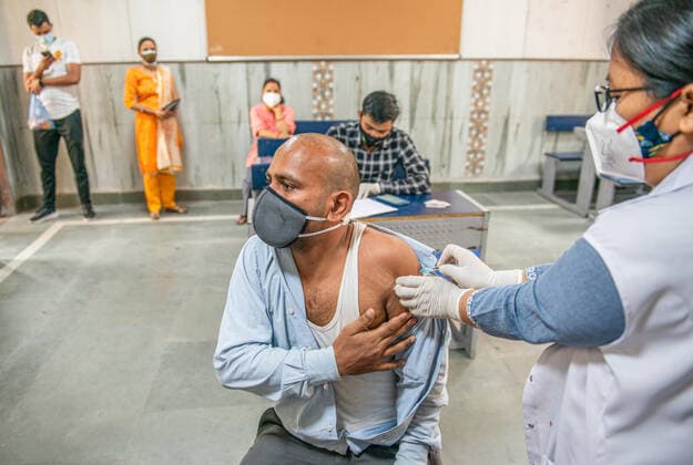May 3, 2021, New Delhi, India: A health worker vaccinates a man at the Sarvoday Kanya Vidyalay West Vinod Nagar where a temporary vaccination centre has been converted..Third phase of Covid-19 Mass Vaccination Drive for People above 18 begins in Delhi capital of India. According to Delhi Deputy Chief Minister Manish Sisodia. 301 Vaccination centres set-up in 76 schools across Delhi, Vaccinating Today 45,100 Delhi Citizens, Next few days 3000 Vaccination centres will start operating in 300 schools across Delhi. New Delhi India - ZUMAs197 20210503_zaa_s197_015 Copyright: xPradeepxGaurx