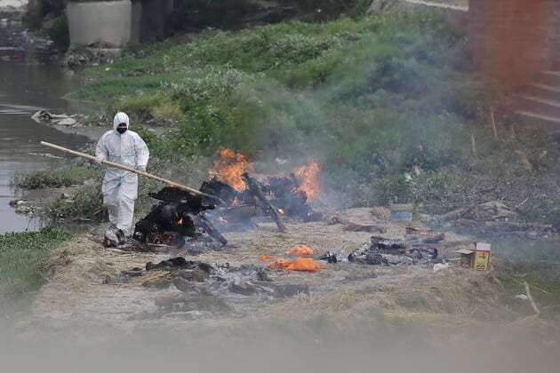 Workers from the crematorium light funeral pyres over the bodies of Covid-19 victim Workers from the crematorium light funeral pyres over the bodies of COVID-19 victims along the banks of the Bagmati river, owing to the second wave of the coronavirus pandemic on the fifth-day of a government imposed lockdown. Nepal Copyright: DipendraxDhungana