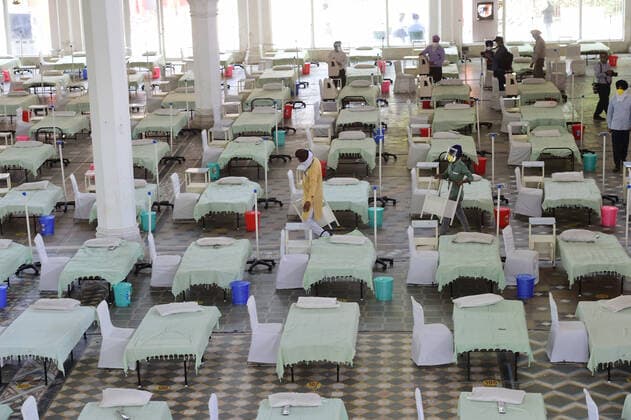 Volunteers set up an temporary COVID-19 care center of 320 beds with oxygen support amid the ongoing second wave of the coronavirus pandemic, at Gurudwara Rakab Ganj Sahib, a Sikh temple, in New Delhi, India, on Monday, May, 3, 2021.  DEL2021050303 Abhishek