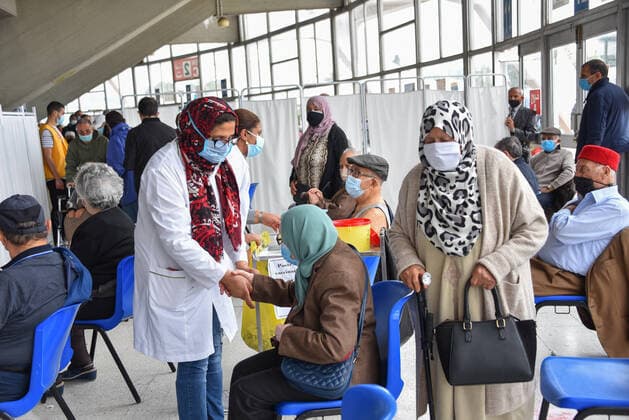 Coronavirus in Tunesien, Impfzentrum in Tunis May 3, 2021, Tunis, Tunisia: A Tunisian healthcare worker assists an elderly woman during inoculation at El-Menzah sports hall in Tunisia s capital. Tunis Tunisia - ZUMAs197 20210503_zaa_s197_058 Copyright: xJdidixwassimx