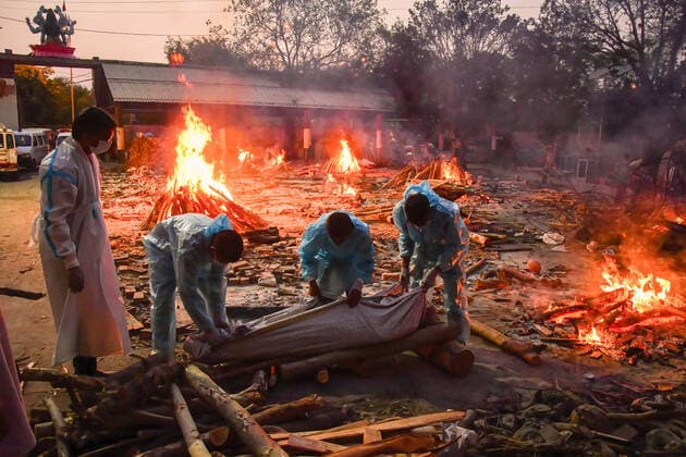 May 3, 2021, New Delhi, India: People perform the last rights of a relative who has died of Covid-19 coronavirus disease as other funeral pyres are seen burning during a mass cremation held at a crematorium..India has recorded a total of 19.9 million cases and 219,000 deaths since the beginning of the outbreak. New Delhi India - ZUMAs197 20210503_zaa_s197_191 Copyright: xManishxRajputx