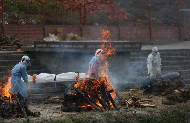 May 4, 2021, Kathmandu, Nepal: Men wearing personal protective equipment (PPE) carry the body of a COVID-19 victim for cremation on the bank of Bagmati River, in Kathmandu, Nepal May 4, 2021. Kathmandu Nepal - ZUMAs242 20210504_zip_s242_001 Copyright: xDipenxShresthax