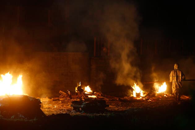May 4, 2021, Kathmandu, Nepal: A man burn bodies of COVID-19 victims along the banks of the Bagmati river, owing to the second wave of the coronavirus pandemic as Nepal reported the highest ever single day Covid-19 fatalities moving upwards with a constant spike to 55 dead, on the sixth-day of a government imposed lockdown at a cremation site in Kathmandu, Nepal on Tuesday, May 4, 2021. Kathmandu Nepal - ZUMAg200 20210504_zap_g200_019 Copyright: xSkandaxGautamx