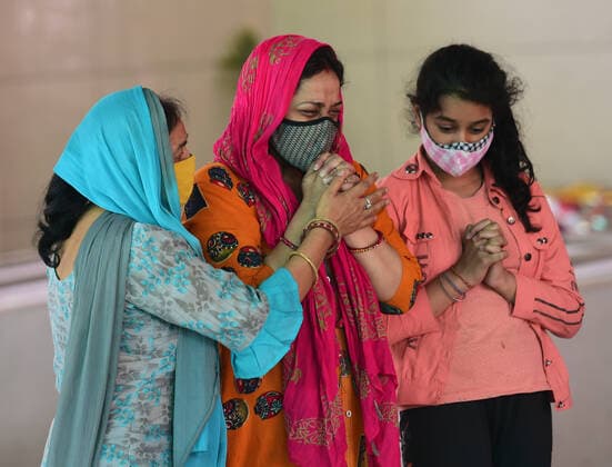 Family members mourn the death of a COVID-19 patient at a crematorium, in New Delhi, India, Tuesday, May 4, 2021. More than 20 million Indians have been infected with the coronavirus as it continues to spread with 3,500 deaths in the past 24 hours.  DEL2021050405 Abhishek