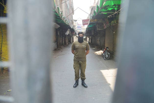 Pakistan: Police personnel stand guard to avoid Public gathering as on the violation of covid-19 Pakistani police personnel is stand guard to avoid Public gathering as on the violation of Corona Virus SOPs the Baghbanpura Market and Pakistani Market is sealed to prevent the spread of COVID-19 in Provincial Capital city Lahore. Lahore Punjab Pakistan Copyright: RanaxSajidxHussain