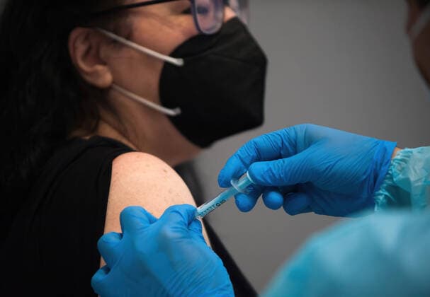 May 5, 2021, Malaga, Spain: A woman wearing a face mask as a precaution against the spread of covid-19 is being vaccinated by a health worker inside a cubicle during a massive vaccination at Fair and Congresses Palace..Health regional authorities have retimed again the vaccination with doses of Pfizer BioNTech inside large and secure places following all protective measures, as part of massive vaccination One million plan after the announcement of Andalusian government to inoculate around 600.000 vaccines during the week. Malaga Spain - ZUMAs197 20210505_zaa_s197_022 Copyright: xJesusxMeridax