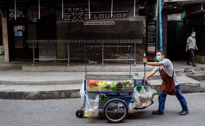 May 5, 2021, Bangkok, Thailand: A Thai man wearing a mask pushes his food cart down a lane in the internationally famous red light district Patpong..Bangkok night life entertainment venues, bars, pubs and restaurants are closed in the designated red zone. A partial lockdown has been imposed for 2 weeks during May 3 -17, 2021, due to a recent upsurge of the Covid C-19 virus outbreak in the capital. Bangkok Thailand - ZUMAs197 20210505_zaa_s197_176 Copyright: xPaulxLakatosx