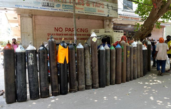 (210506) -- NEW DELHI, May 6, 2021 -- People wait to refill oxygen cylinders for COVID-19 patients at Jangpura area in New Delhi, India, on May 5, 2021. (Photo by Xinhua) INDIA-NEW DELHI-COVID-19 ParthaxSarkar 