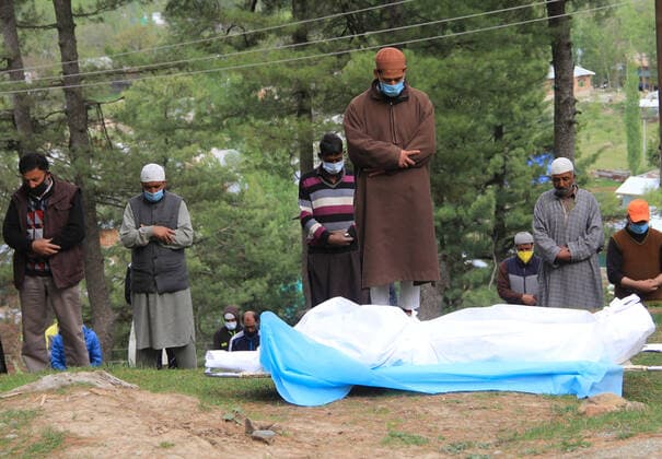May 6, 2021, SRINAGAR, JAMMU AND KASHMIR, INDIA: Relatives offer funeral prayers next to the coffin containing the body of a 60 years old Muslim woman who died from the coronavirus disease (COVID-19), before burying it at the graveyard in Tangmarg, some 44 kilometres North of srinagar city on April. 06, 2021. SRINAGAR INDIA - ZUMAs260 20210506_zip_s260_002 Copyright: xSajadxHameedx