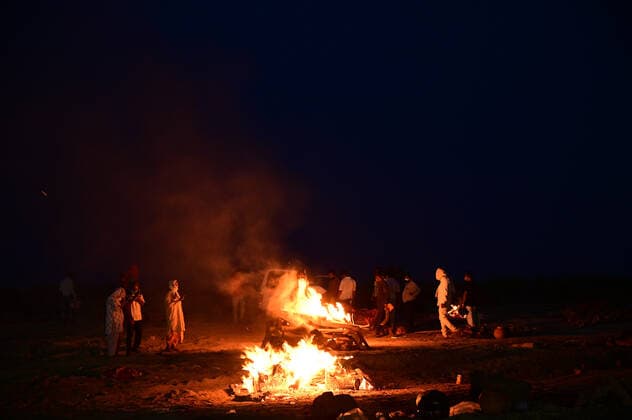 May 6, 2021, Prayagraj, Uttar Pradesh, India: Relatives perform last rites of a family member who was said to have died of Covid-19 to a funeral pyre at a mass crematorium site on the banks of the Ganga river in Allahabad. A new wave of the pandemic has totally overwhelmed the country s healthcare services and has caused crematoriums to operate day and night as the number of victims continues to spiral out of control. Prayagraj India - ZUMAv115 20210506_zap_v115_034 Copyright: xPrabhatxKumarxVermax